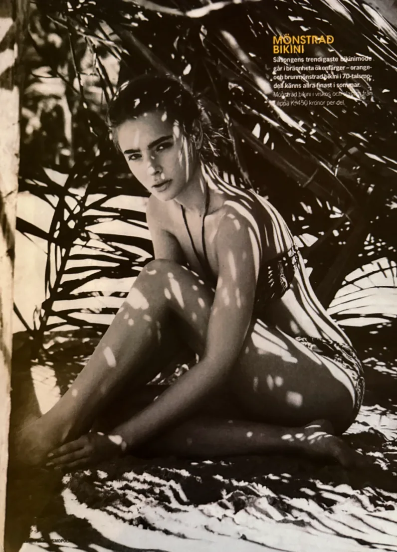 May Gil model in a natural beach setting, in a seated pose